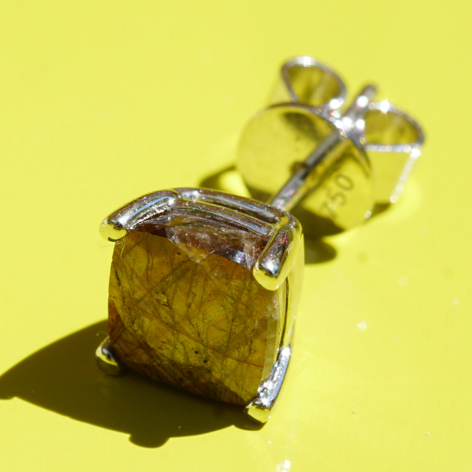 Single ear stud with a rare gold colored sapphire