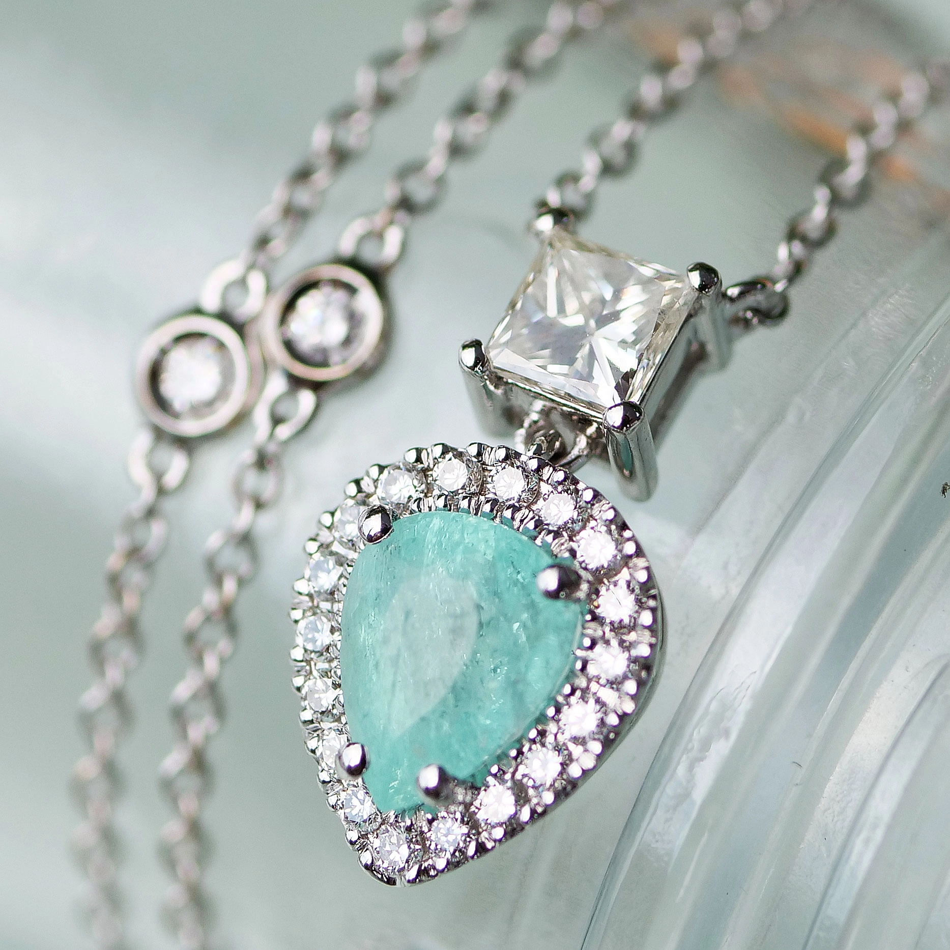 great paraiba turmalin of 1.18 ct, AAA brilliant. swimmingpool blue-green color, original from brasil, 18 kt whitegold, combinated with a princess cut diamond 0.36 ct