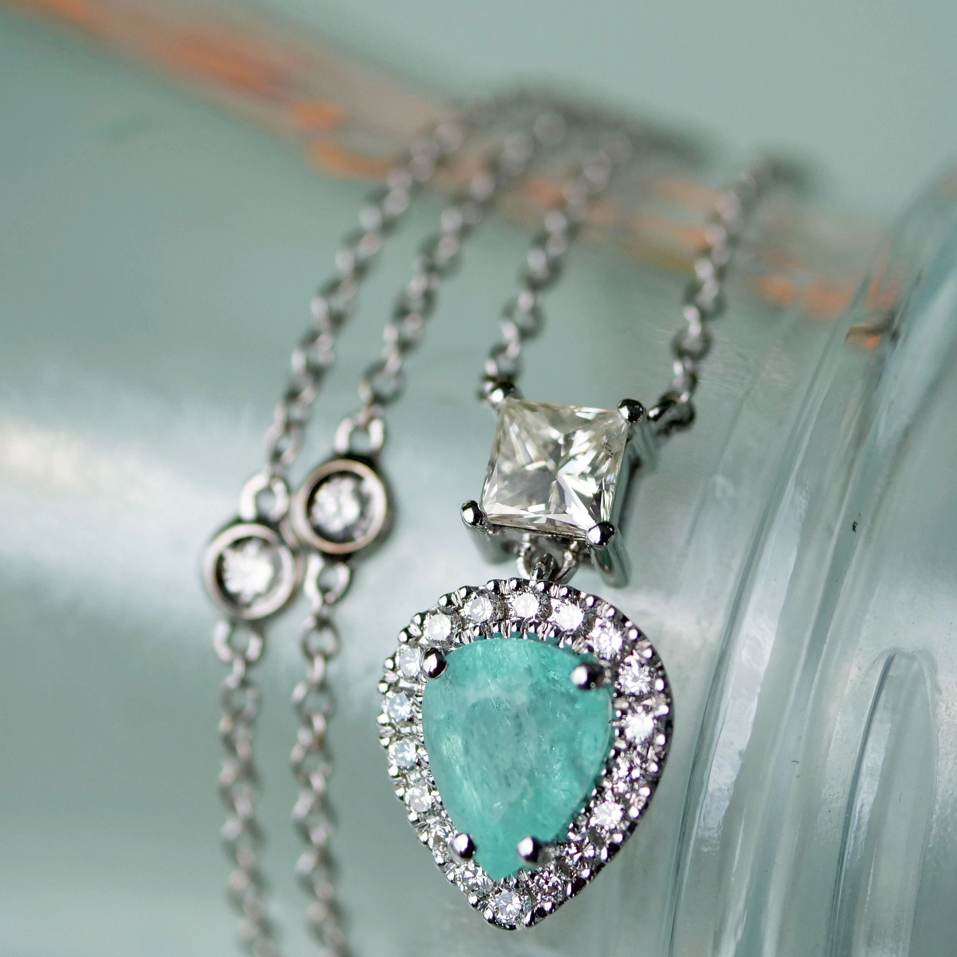 great paraiba turmalin of 1.18 ct, AAA brilliant. swimmingpool blue-green color, original from brasil, 18 kt whitegold, combinated with a princess cut diamond 0.36 ct